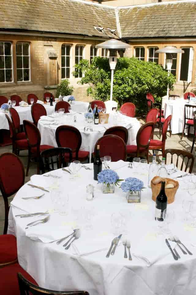 Elegant outdoor dining setup with floral centerpieces for a sophisticated event.