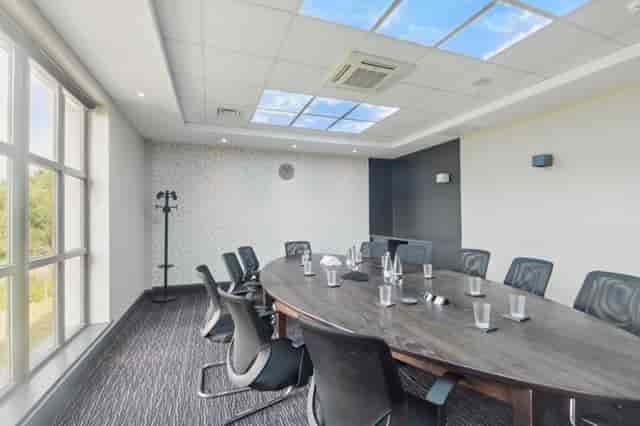 Modern meeting room with oval table, ideal for workshops and strategic planning.