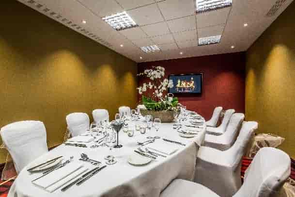 Executive Boardroom 1-3 at Holiday Inn, elegant table with orchids, perfect for meetings.