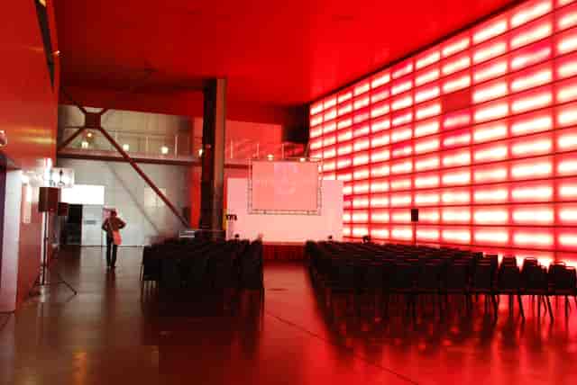 Modern event space in The Red Hall, featuring a striking red wall for presentations.