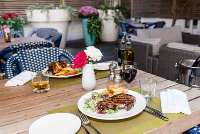 Outdoor dining table with steak, perfect for networking dinners and celebrations.