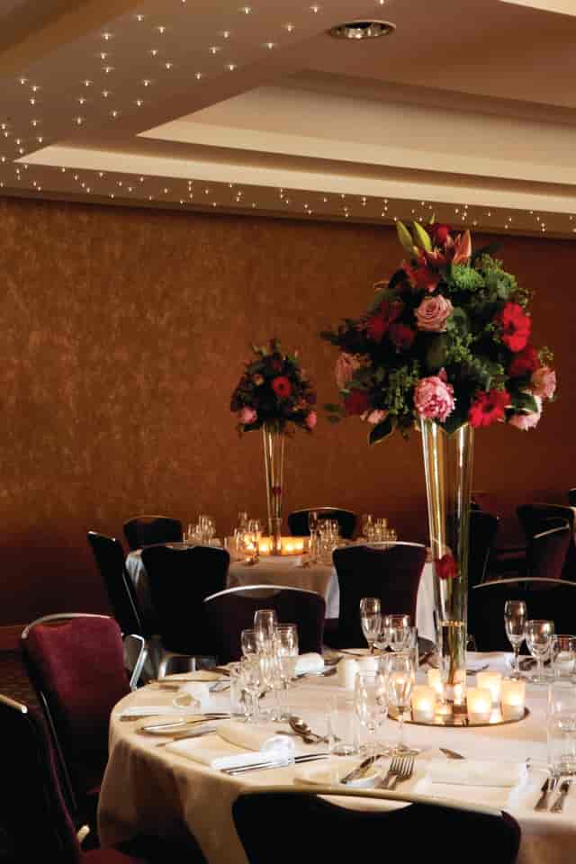 Elegant dining table with floral centerpieces in Wimbledon Room, perfect for upscale events.