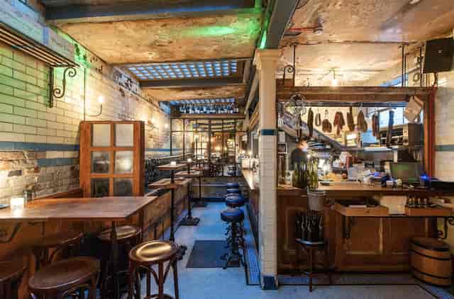Wine bar in converted loo with rustic decor, perfect for intimate gatherings and networking.