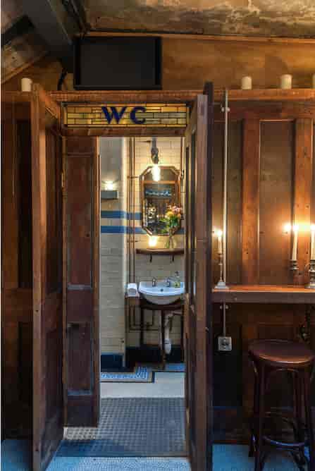 Wine bar in converted restroom with vintage decor, perfect for events and gatherings.