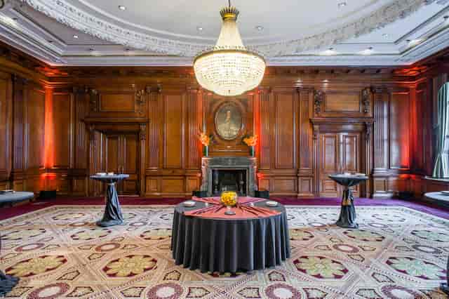 Elegant Council Room with wooden paneling and chandelier for upscale events.
