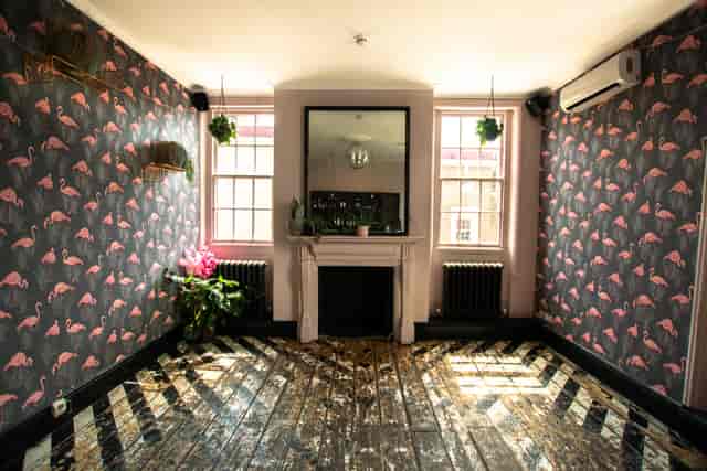 Stylish event space with flamingo wallpaper, ideal for workshops and intimate gatherings.