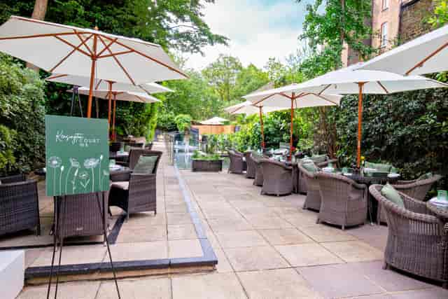 Elegant outdoor event space at Holiday Inn Kensington with lush greenery and seating.