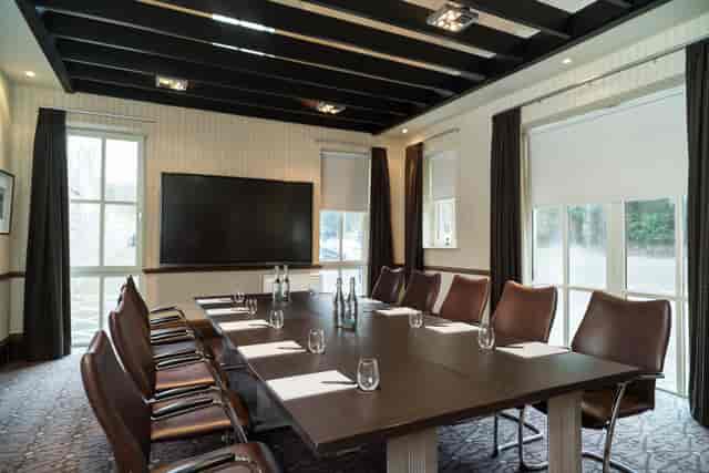 Boardroom meeting at Norton House Hotel: sleek leather chairs and tech-ready setup for executives.