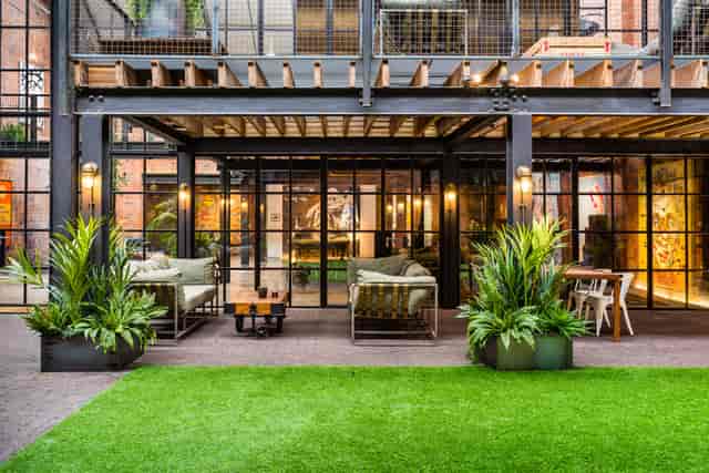 Stylish outdoor meeting space with glass walls for networking and events in The Compound.