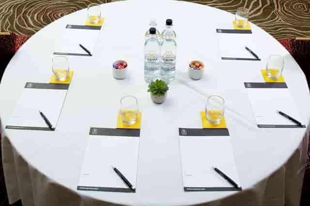 Charles Suite meeting setup with round table, notepads, and succulents for collaboration.