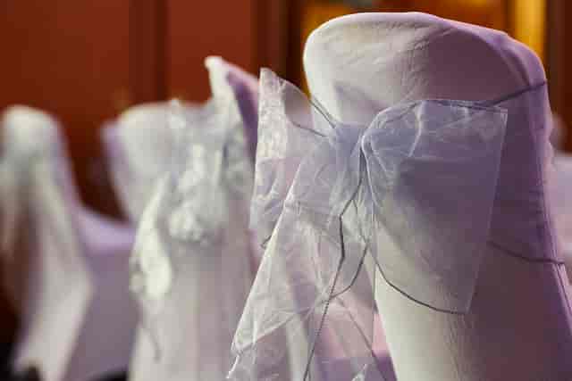 Elegant chair covers with sheer bows at Charles and James Suites for upscale weddings.