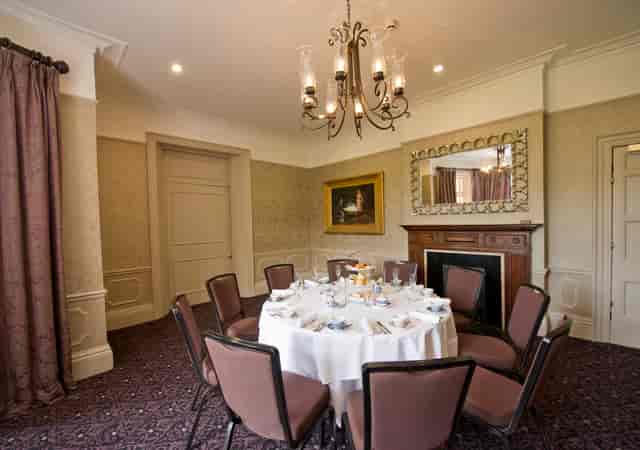 Elegant meeting space with round table for upscale events at Woodlands Park Hotel.