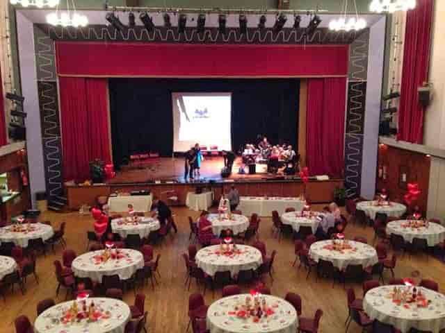 Main Hall in Brierley Hill Civic Hall set for a formal event with round tables and stage.