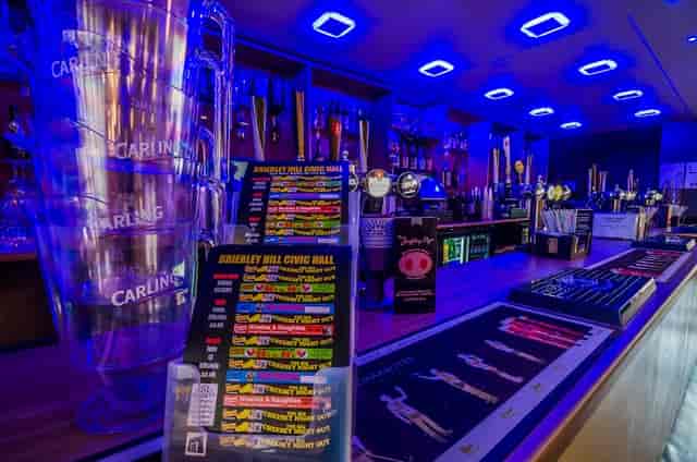 Vibrant bar area with blue lighting, perfect for networking events and social gatherings.