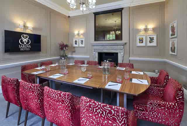 Sienna Room in Sir Christopher Wren: elegant meeting space with plush red chairs.