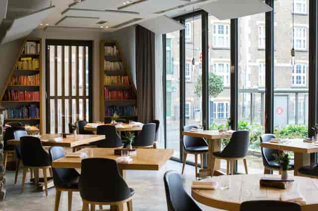 Modern restaurant with round tables, ideal for networking events and intimate gatherings.
