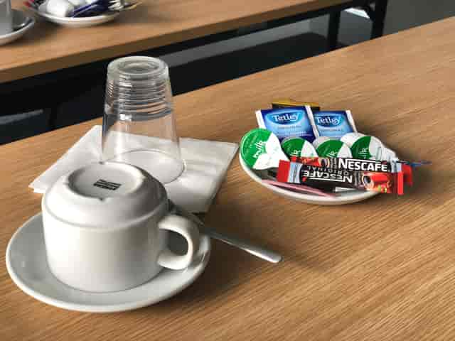 Coffee setup in Enterprise House Room 019 for meeting breaks, featuring creamers and sweeteners.