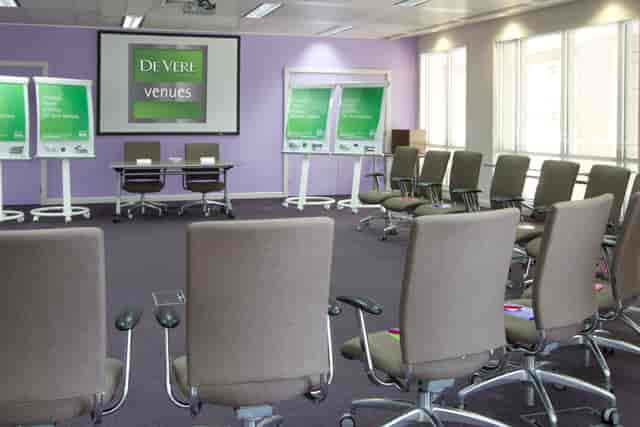 U-shaped meeting room with ergonomic chairs for collaborative workshops and training events.