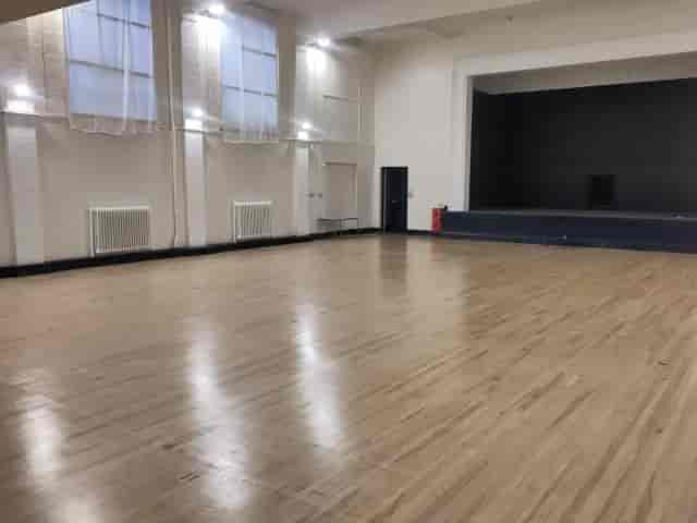 Spacious seminar room with polished wooden floors for conferences and workshops.