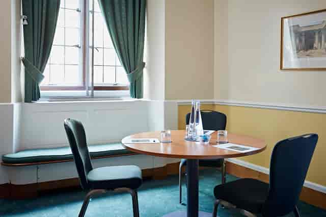 Intimate meeting room with round table, ideal for brainstorming and strategy sessions.