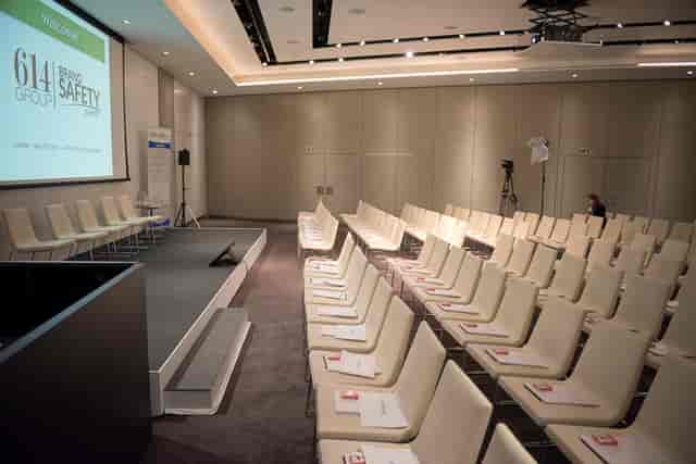 Modern conference setup in ME London Event Space with white chairs and presentation tech.