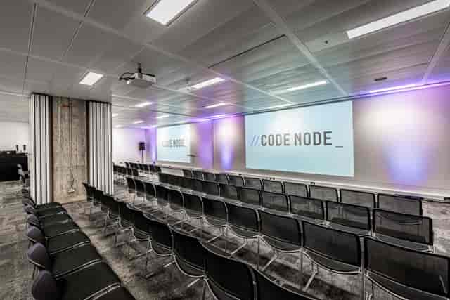 Modern tech conference, tiered seating, dual screens