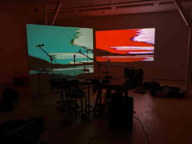 Creative event venue with vibrant projections and stage for live performances.