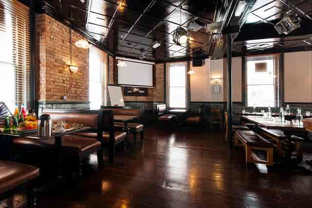 Upstairs Private Bar: rustic meeting space with exposed brick, ideal for workshops and team meetings.