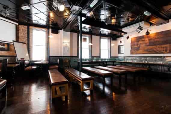 Upstairs Private Bar: versatile event space with wooden benches, ideal for workshops and networking.