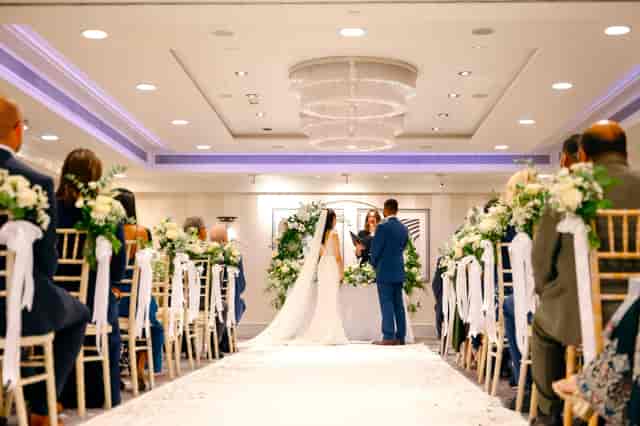 Elegant wedding ceremony in Mayfair Suite, Sofitel London with floral decor and chandelier.