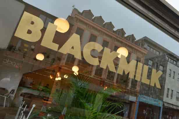 Black Milk Cafe storefront with large windows, ideal for casual gatherings and networking events.
