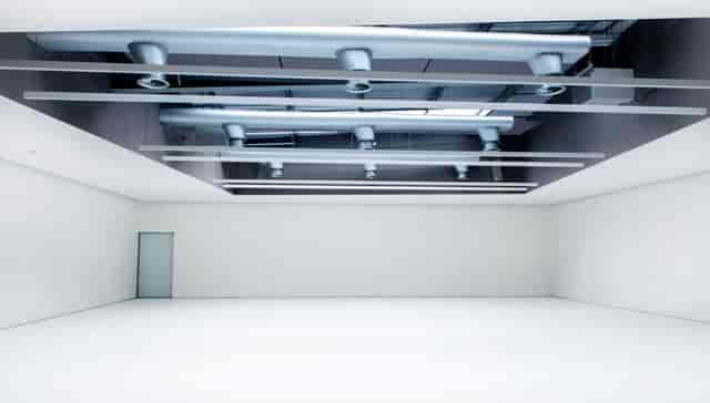 Minimalist event space with high ceiling, ideal for conferences and workshops.