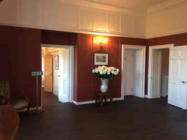 Wren House meeting space with red walls, ideal for intimate gatherings and conferences.