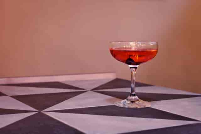 Elegant cocktail in coupe glass at upscale cafe bar, perfect for networking events.