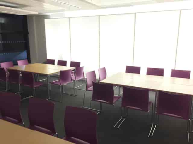 Modern meeting room at Queen Mary University with purple chairs, ideal for workshops.