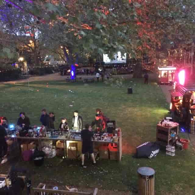 Vibrant outdoor event at The Museum of the Home with bar and lush greenery.