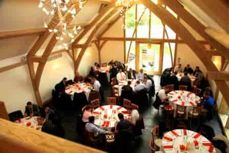 Oak Barn event space with round tables, ideal for corporate gatherings and celebrations.