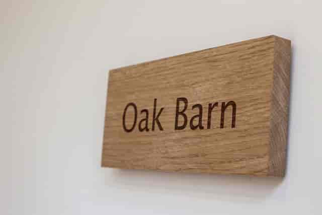 Oak Barn sign at Mythe Barn, rustic venue for intimate gatherings and workshops.
