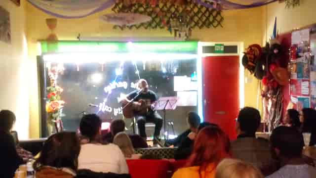 Intimate live performance at Garden Community Cafe with warm lighting and cozy atmosphere.