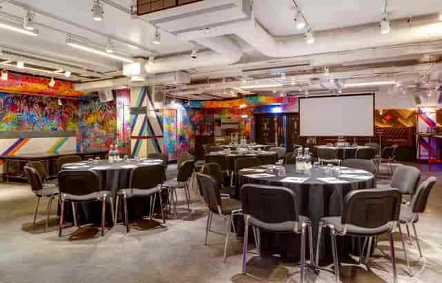 Vibrant conference space with round tables, ideal for meetings and networking events.