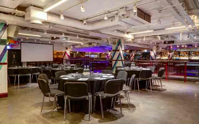 Versatile event space in Bounce Old Street, set for meetings and banquets with round tables.