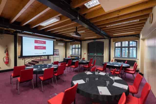 Boulton Room at IET Birmingham: Austin Court, featuring round tables and a large screen.
