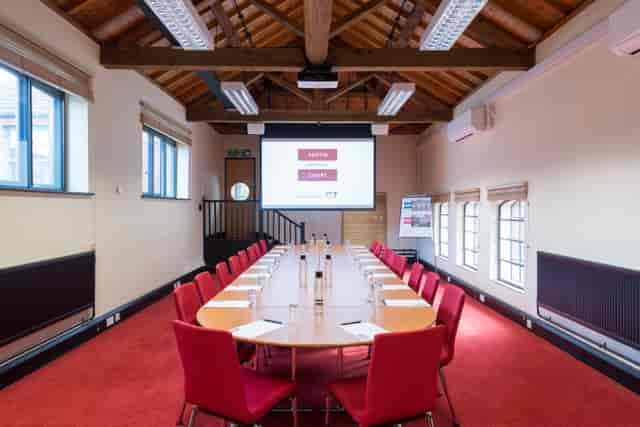 Crompton Room at IET Birmingham: oval table, red chairs, ideal for workshops and meetings.