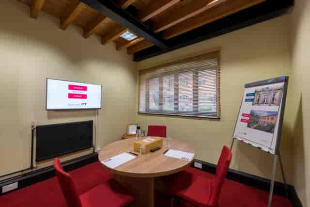 Edison Room at IET Birmingham: modern meeting space with round table for collaboration.