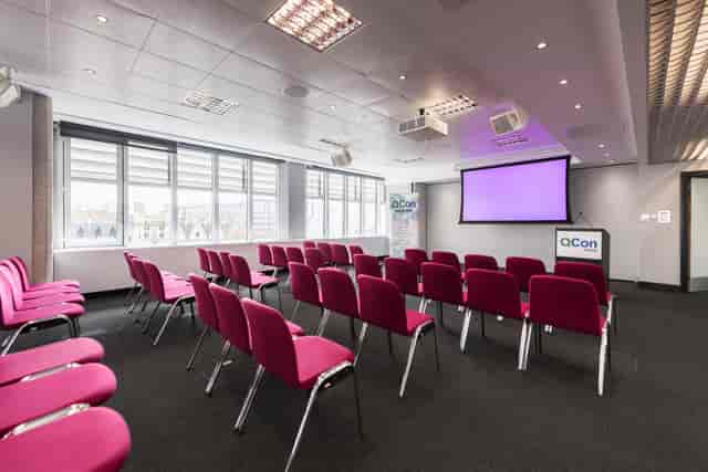 Abbey in QEII Centre meeting room with pink chairs, ideal for workshops and seminars.