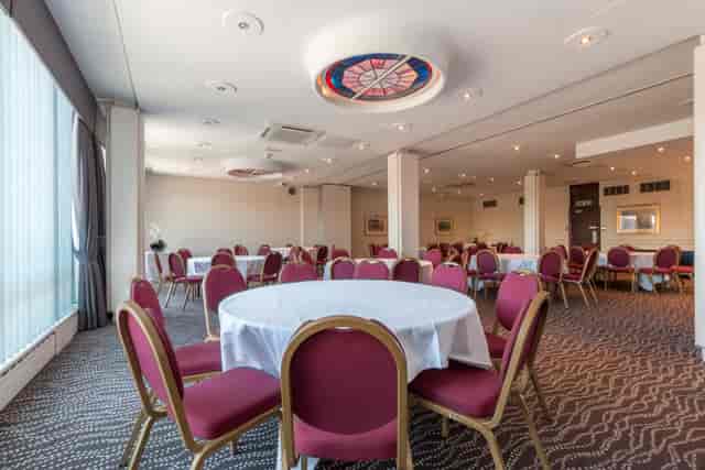 Print Room at Thistle London Heathrow: versatile event space with round tables for meetings.