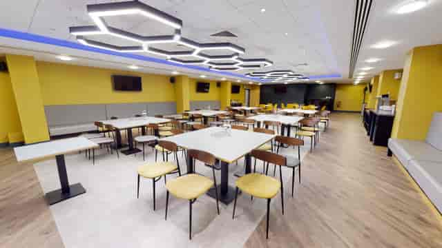 Modern event space in Molineux Stadium with yellow walls, ideal for meetings and gatherings.
