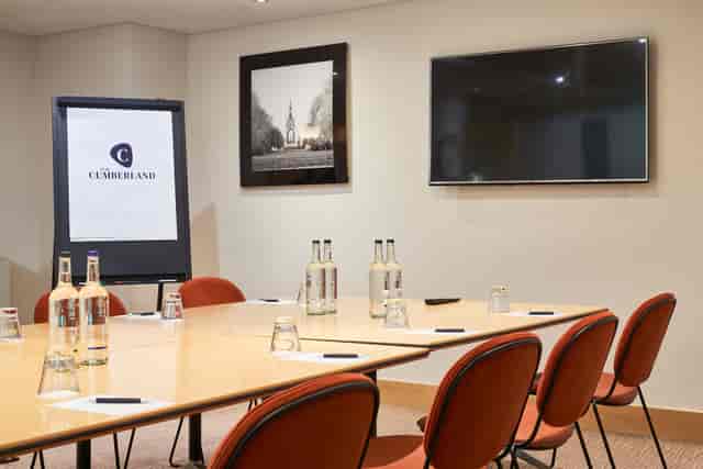 Modern meeting room in The Cumberland Hotel with large table and presentation TV.