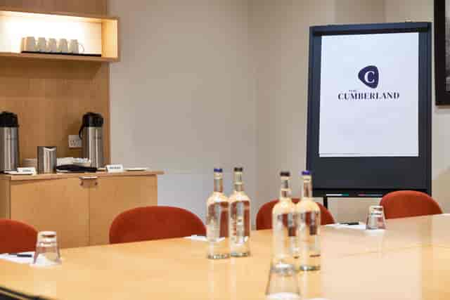 "Studio 8 meeting room at The Cumberland Hotel with polished table and branding."