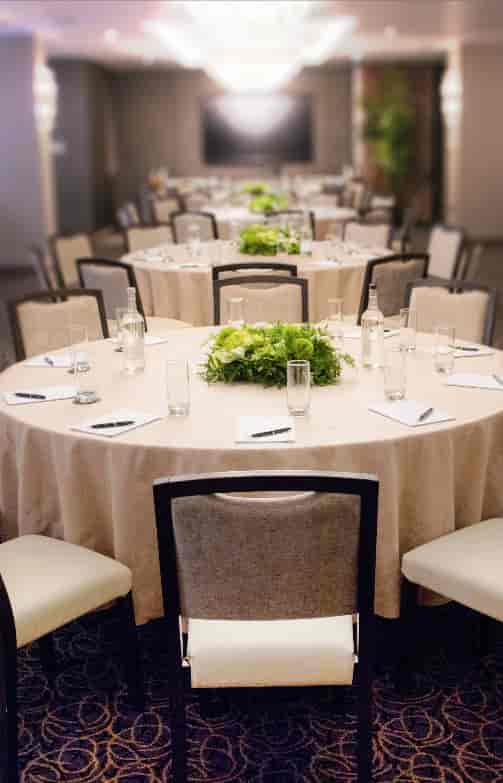 Royal London Suite meeting setup with round tables, greenery centerpieces for workshops.